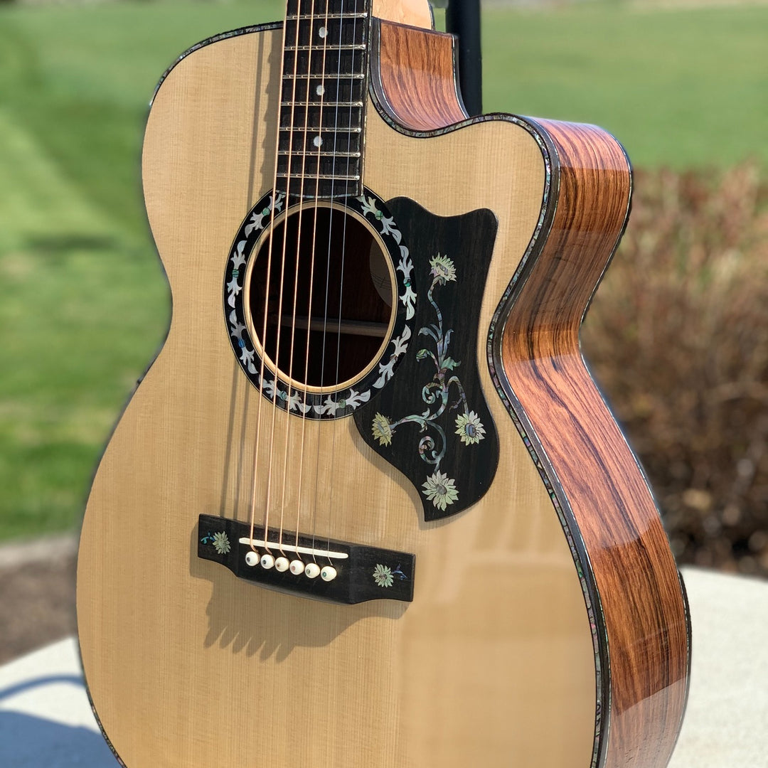 Acoustic Guitar in light wood grain on the front and darker wood grain on the sides