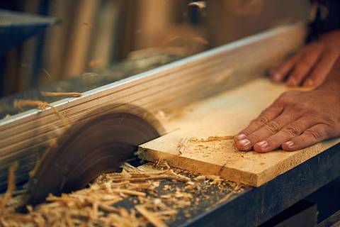 unfinished wood being cut with saw