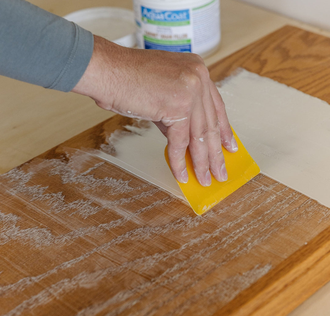 Aqua Coat Grain Filler being applied to a piece of wood with a yellow sponge
