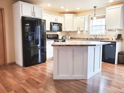 refinished kitchen with white cabinets and black appliances