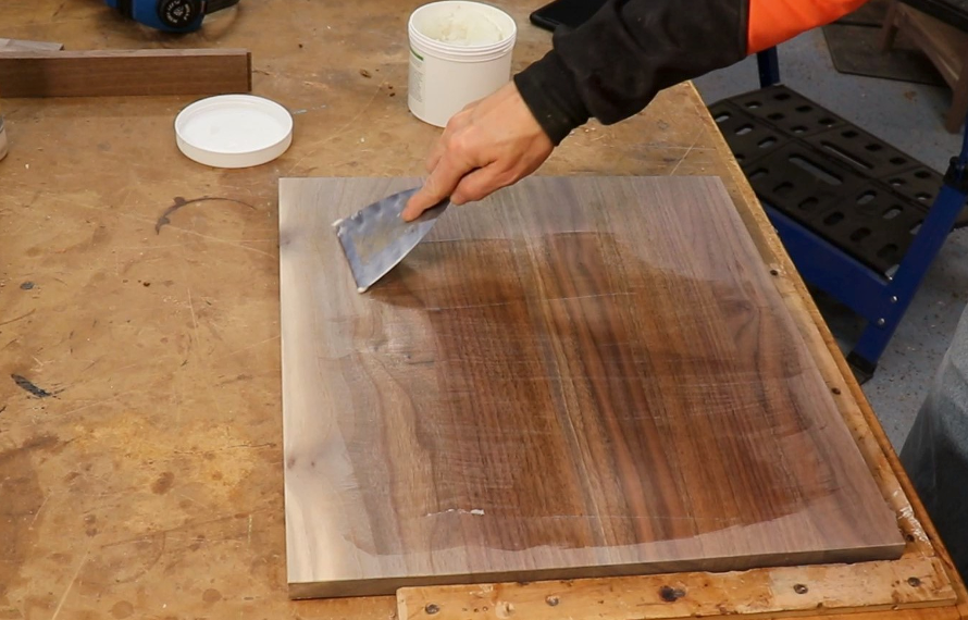 Aqua Coat grain filler being applied to a piece of wood with a putty knife