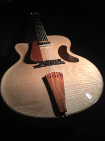 jazz guitar with light colored wood finish on a black background